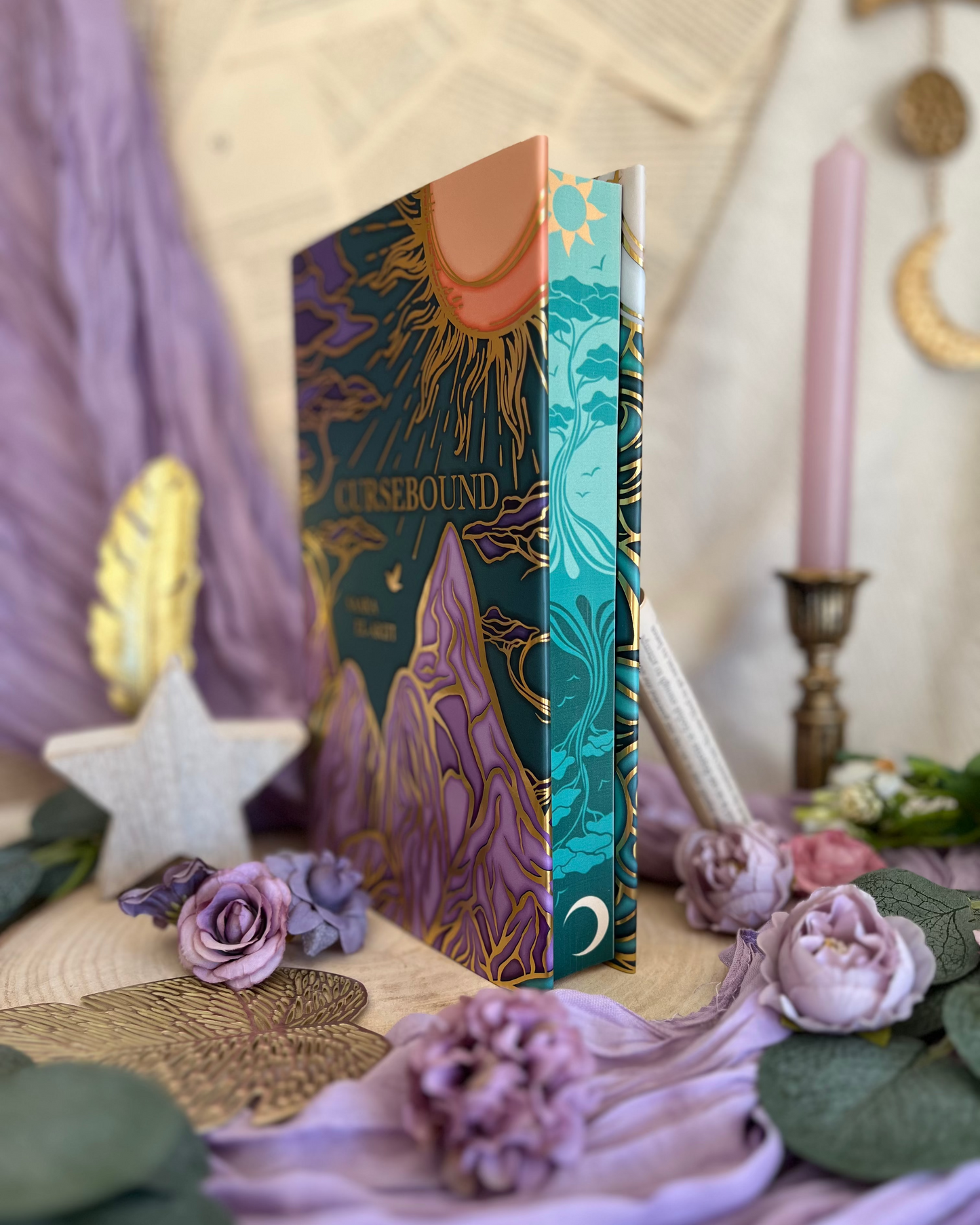 Decorative book titled 'Cursebound' on a mystical setting with flowers and candles.