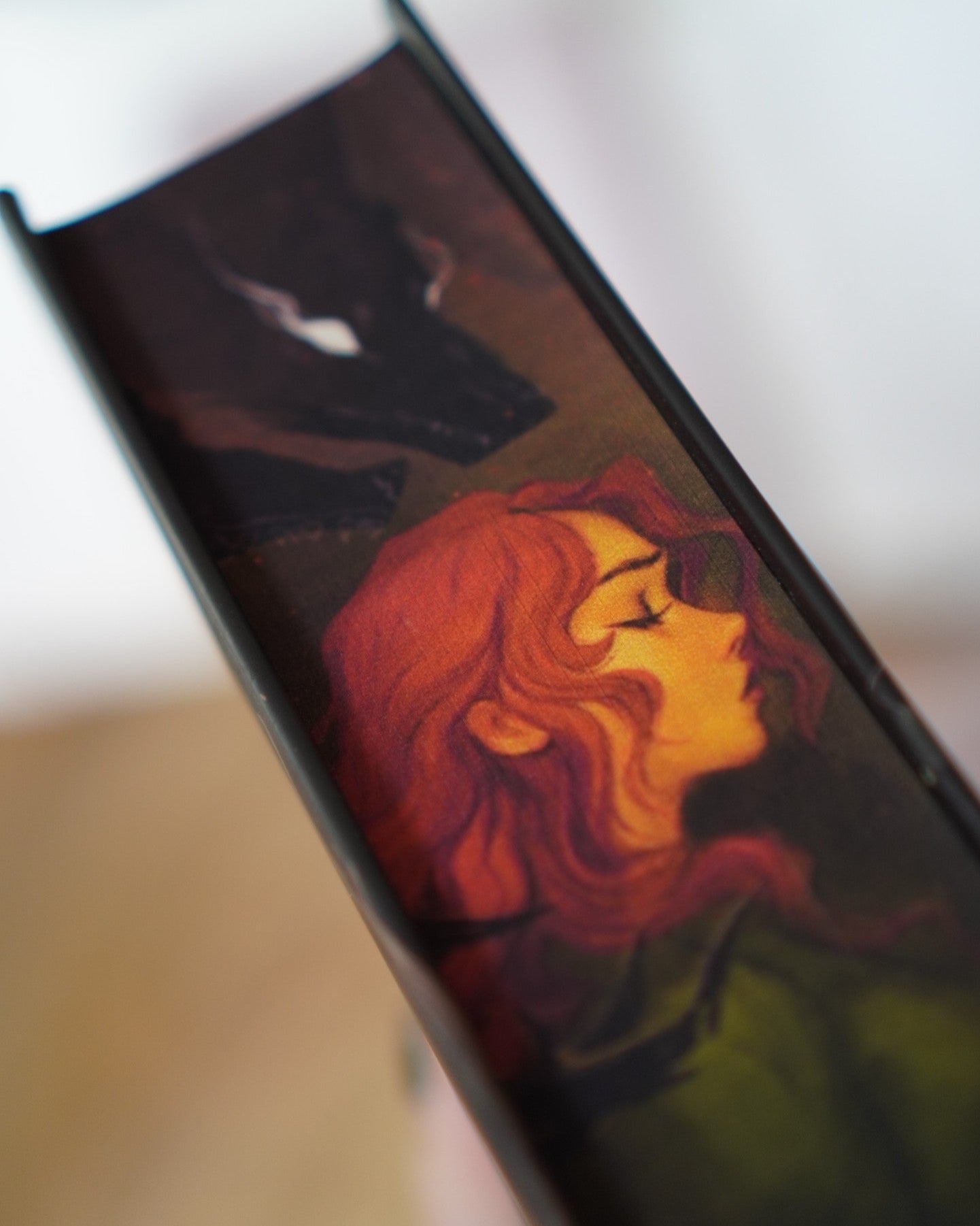 Close-up of a book edge displaying an artistic depiction of a woman with red hair.